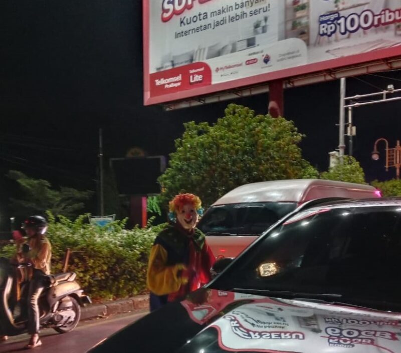 Seorang Badut sedang menghibur pengendara di simpang Taman Ratu Safiatuddin Banda Aceh 